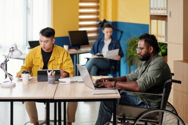 Muhtelif iş ekipleriyle çalışan engelli bir adam.