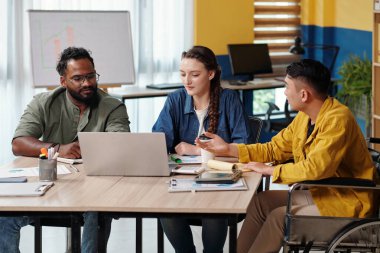 Çeşitli pazarlama departmanı dizüstü bilgisayardaki ürün sunumunu izledikten sonra toplantıda konuşuyor