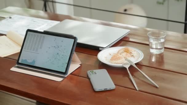 智能手机 水杯以及咖啡店里没有人的糕点上有商业信息的数码平板电脑的中景照片 — 图库视频影像