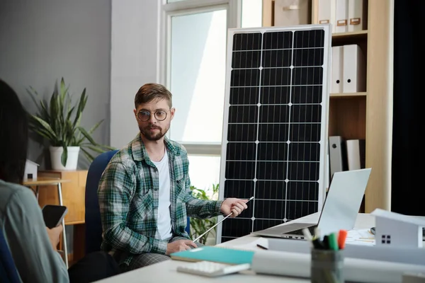ソーラーエンジニアは 太陽光パネルの作業原理を説明するクライアントと話す — ストック写真