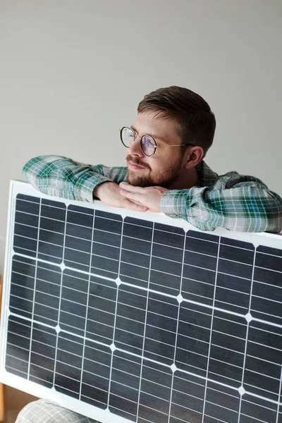 stock image Happy young man in glasses leaning on solar panel and dreaming