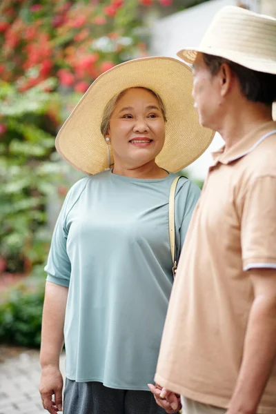 戴着草帽的快乐的老年妇女带着爱意和柔情看着她的丈夫 — 图库照片