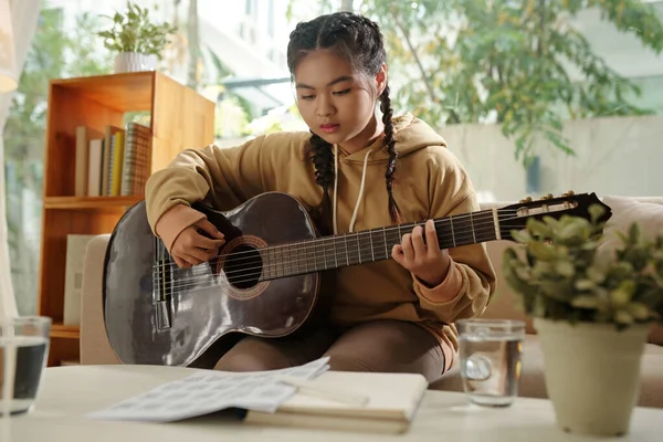 Talentiertes Teenager Mädchen Schaut Beim Gitarrespielen Auf Notenblätter — Stockfoto