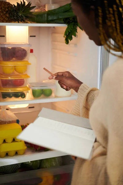 Женщина Открывает Холодильник Записывает Список Покупок — стоковое фото