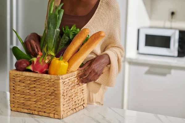 女人把一篮子新鲜食品放在厨房柜台上 — 图库照片