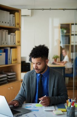 Toplantı için rapor verirken kafası karışmış işadamının belgelerle çalışması
