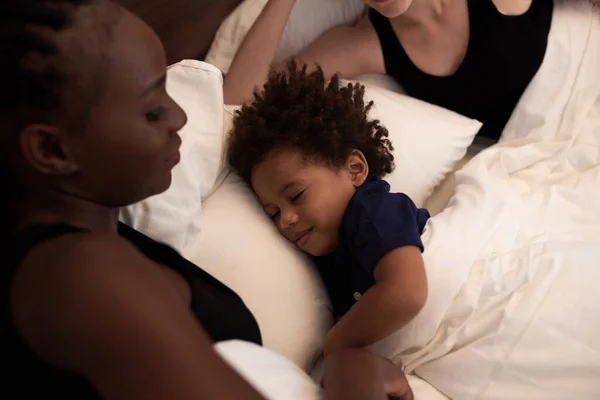 彼の両親のベッドで眠っている穏やかな幸せな男の子 共同睡眠とベッドの時間のルーチンの概念 — ストック写真
