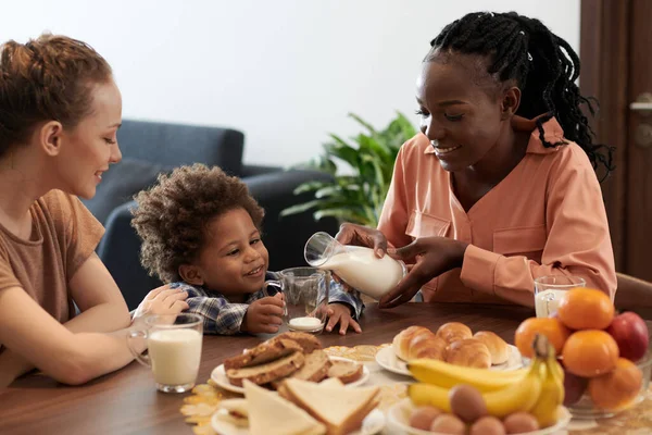 Lächelnde Junge Mutter Gießt Milch Tasse Für Ihren Kleinen Jungen — Stockfoto