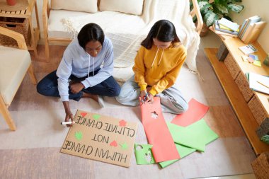 Üniversite öğrencileri, yaklaşan küresel iklim değişikliği protestoları için yatakhane odasında pankart hazırlıyorlar.