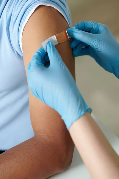 护士手将胶粘剂绷带贴在疫苗注射地点 — 图库照片