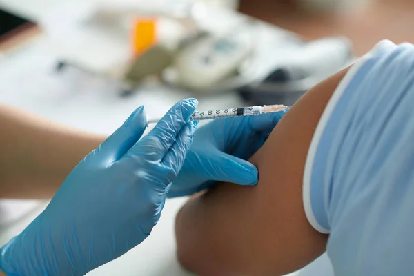 患者の肩にウイルスに対してワクチンを注射する医療看護師のイメージを閉じる — ストック写真
