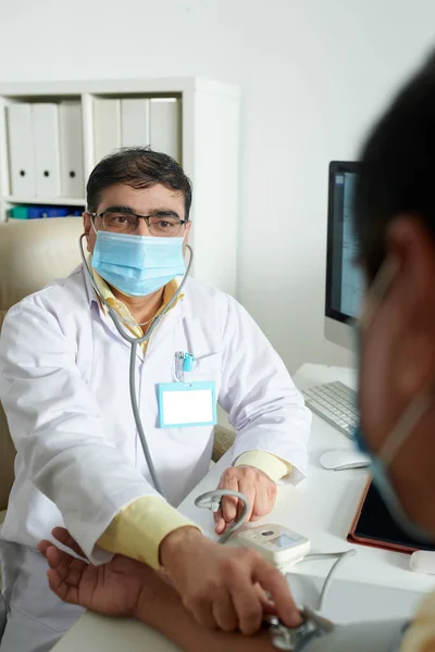 Tıbbi Maskeli Pratisyen Hekim Kıdemli Hastanın Kan Basıncını Ölçüyor — Stok fotoğraf