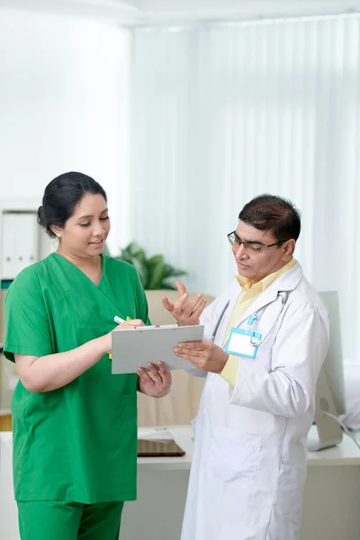 Çeşitli Doktor Hemşireler Klinik Resepsiyonunda Sağlık Raporlarını Tartışıyorlar — Stok fotoğraf