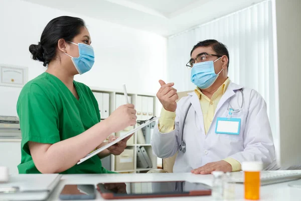 Lekarz Chirurg Maskach Medycznych Omawiający Finansowanie Szpitalne Podczas Pandemii — Zdjęcie stockowe