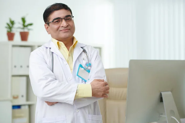 肯定的な自信を持つインドの一般開業医の肖像腕を横断し カメラを見て — ストック写真