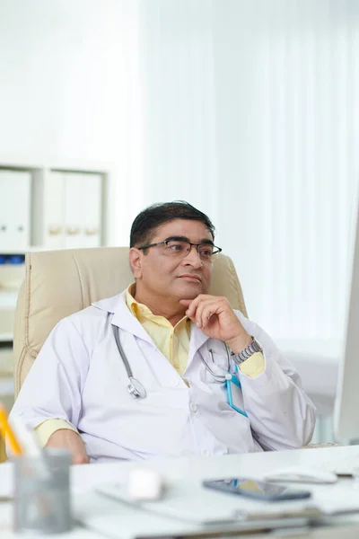 Serious Doctor Leaning Back His Armchair Reading Document Computer Screen — Stock Photo, Image