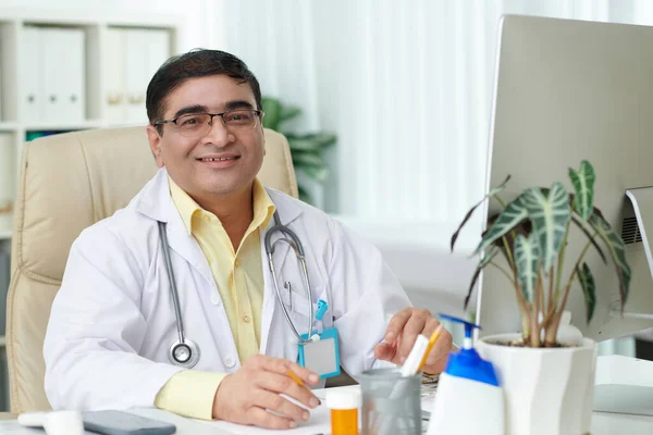 Porträt Eines Lächelnden Allgemeinmediziners Mit Brille Schreibtisch Seinem Büro — Stockfoto