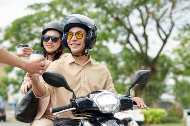 Mobiletle gezen neşeli genç bir çift kahve siparişi veriyor.