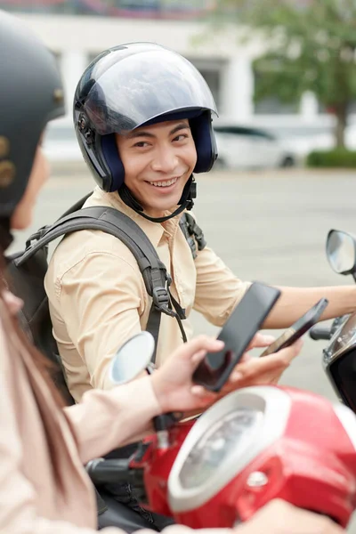 穿着防护头盔的年轻人坐在摩托车上与朋友交谈的画像 — 图库照片