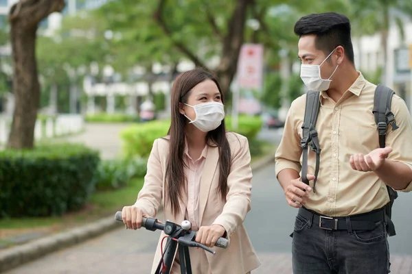 Smiling Colleagues Medical Masks Riding Electric Scooters Discussing Project Details — Stock Photo, Image
