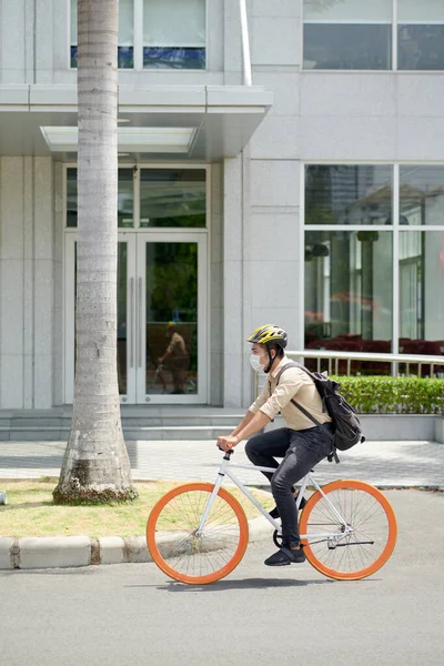 도시에서 자전거를 헬멧을 의료용 마스크를 젊은이 — 스톡 사진