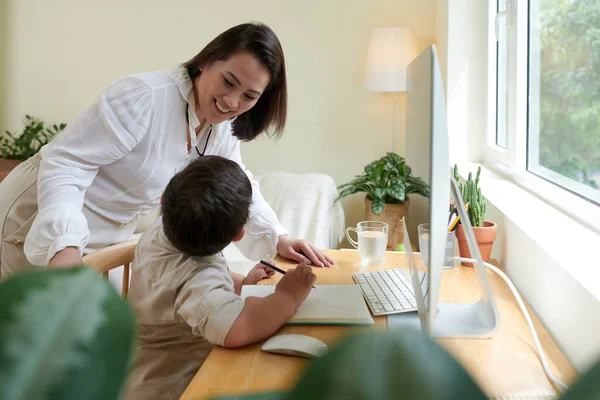 Glimlachende Moeder Kijkt Hoe Haar Zoon Thuis Studeert Als Gevolg — Stockfoto
