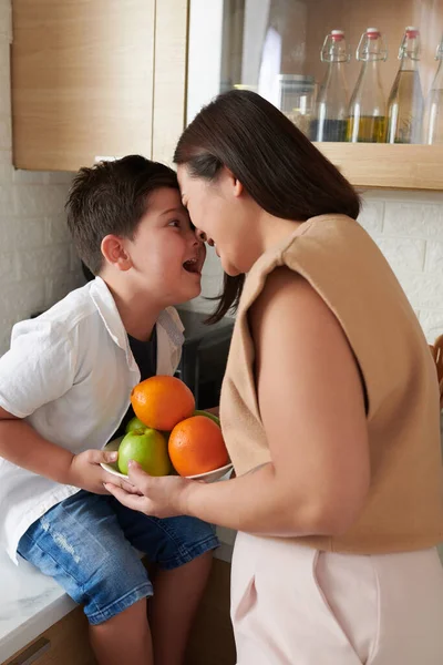 母亲和小儿子拿着一碗水果 摸着额头来表达爱意 — 图库照片