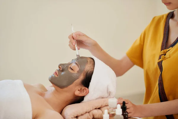Esteticista Aplicando Clareamento Hidratação Máscara Barro Rosto Cliente Feminino — Fotografia de Stock