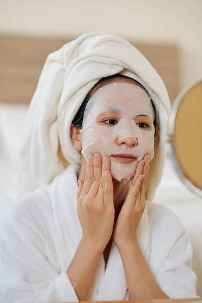 Ung Kvinna Som Applicerar Sheet Face Mask För Att Återfukta — Stockfoto