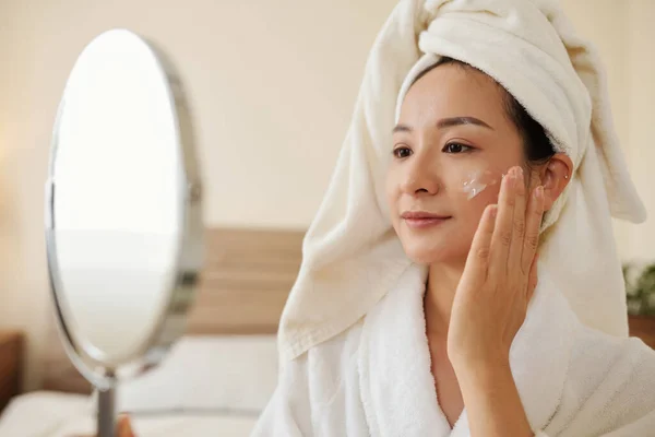 목욕하는 긍정적 여성은 거울의 확대경을 로션을 — 스톡 사진