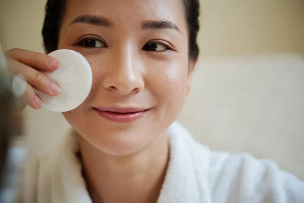 亚洲女人用浸透墨粉的棉垫擦拭脸的笑脸 — 图库照片