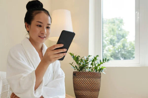 Usmívající Mladá Žena Županu Čtení Textových Zpráv Upozornění Smartphone — Stock fotografie