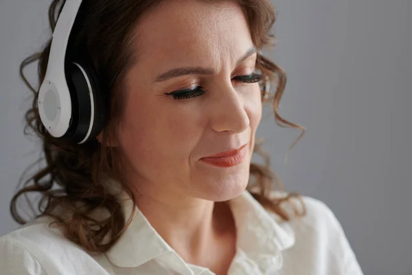 Dojrzała Kobieta Słuchająca Muzyki Lub Audiobooka Słuchawkach — Zdjęcie stockowe