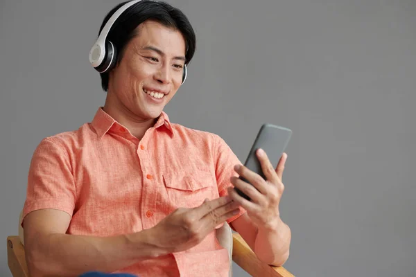 Glimlachende Man Die Muziek Kiest Uit Afspeellijst Smartphone — Stockfoto