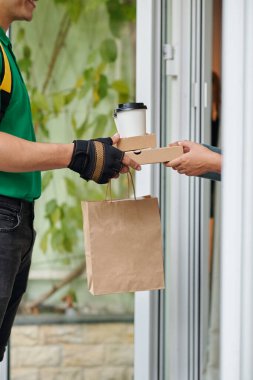 Kurye müşteriye yemek getiriyor.