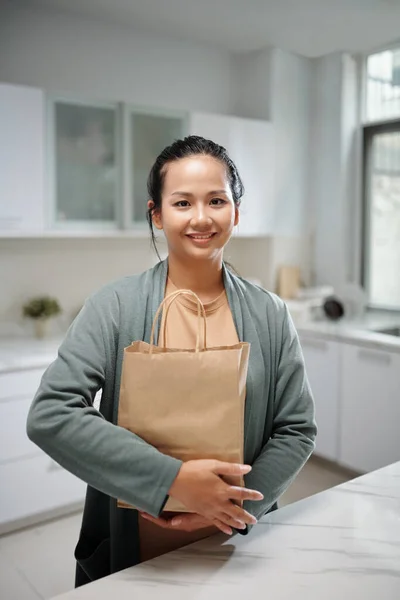 Portrét Usměvavé Ženy Pohodlných Šatech Stojící Kuchyňského Pultu Papírovým Balíčkem — Stock fotografie