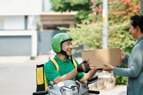 Χαμογελώντας Courier Κάθεται Σκούτερ Και Δίνοντας Κουτί Στον Πελάτη — Φωτογραφία Αρχείου