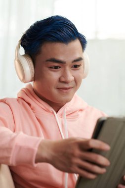 Tablet bilgisayardan eğlenceli videolar izleyen heyecanlı genç adam