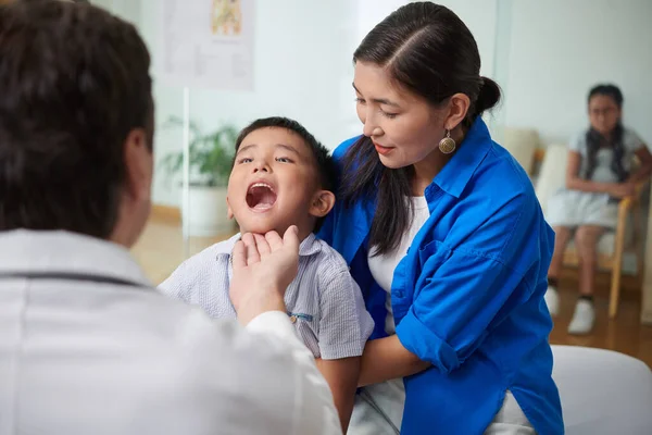 Çocuk Doktoru Boğazını Kontrol Edebilmek Için Çocuğa Ağzını Kocaman Açmasını — Stok fotoğraf