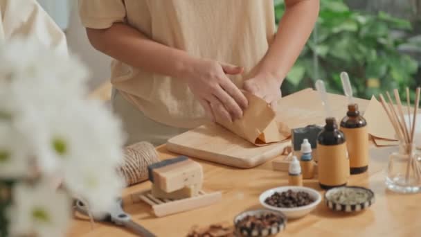 两个无法辨认的女人将有机手工肥皂用手工纸包在木制桌子上的剪影 — 图库视频影像