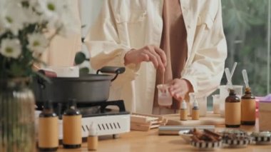 Parlak geniş atölyede organik kozmetik yapan iki genç kadın.