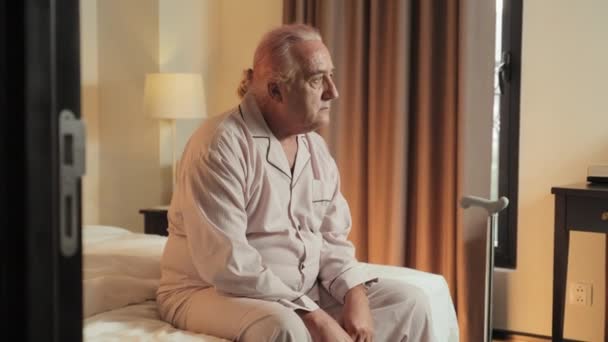 Zoom Shot Van Bedachtzame Oudere Man Pyjama Zitten Bed Avond — Stockvideo