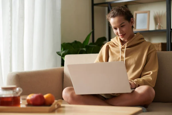 Glimlachende Jonge Vrouw Zitten Bank Thuis Codering Laptop — Stockfoto