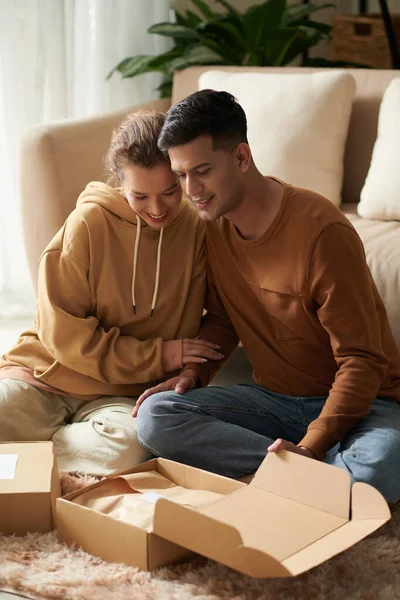 Usmívající Mladý Pár Lásce Vybalování Krabice Oblečením Které Objednali Online — Stock fotografie
