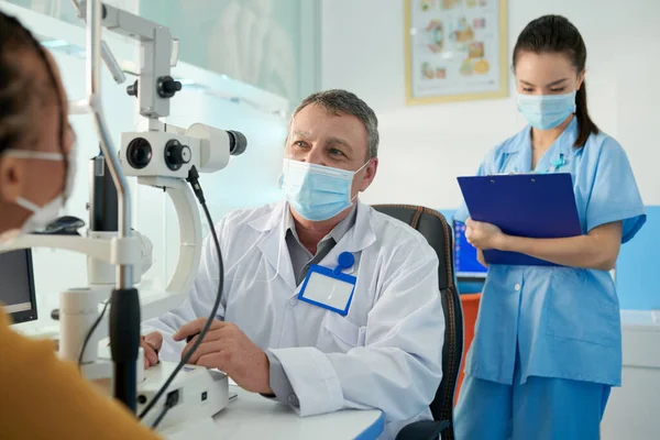 Doświadczony Lekarz Korzystający Nowoczesnego Sprzętu Podczas Sprawdzania Wzroku Pacjenta Pielęgniarka — Zdjęcie stockowe