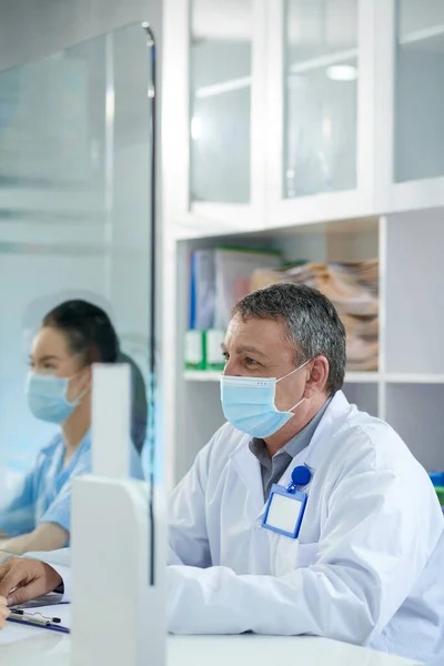 Ανώτερος Ιατρός Ιατρική Μάσκα Που Εργάζεται Στην Κλινική Υποδοχής Συμβουλεύεται — Φωτογραφία Αρχείου