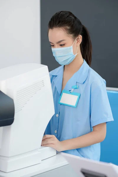 Retrato Una Joven Enfermera Oftálmica Que Revisa Información Sobre Autorefractómetro —  Fotos de Stock