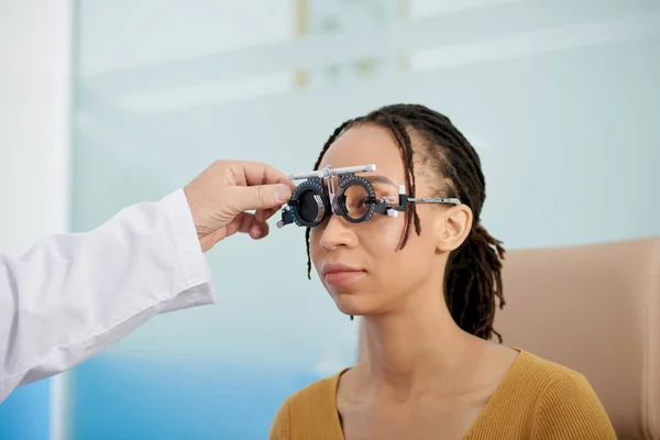患者の目の間の距離を測定するために調整可能な光学試験レンズフレームを使用して眼科医 — ストック写真