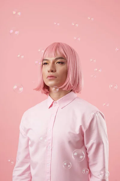 若いですアジアの男の肖像とともに美しい目の表情とピンクのボブヘアカット立ち下落ちる石鹸泡 — ストック写真
