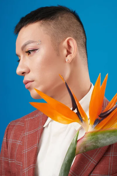Calm Sad Young Man Eyeliner Rhinestones Makeup Holding Strelitzia Flower — Stock Photo, Image